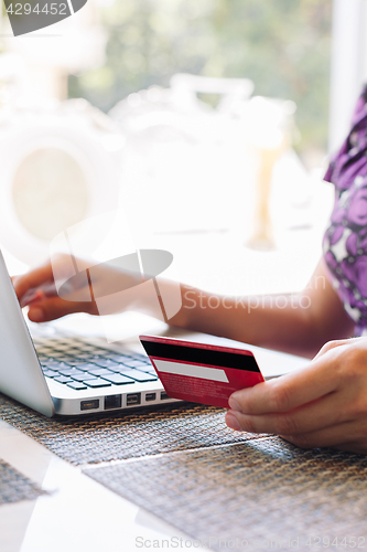 Image of Woman with laptop and credit card in the cafe.