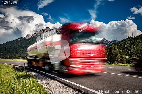 Image of Fuel truck rushes down the highway in the background the Alps. T