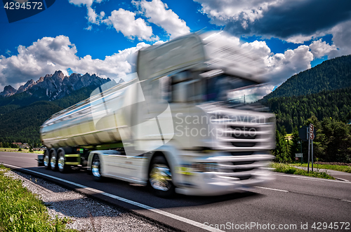 Image of Fuel truck rushes down the highway in the background the Alps. T