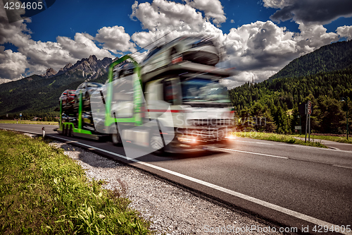 Image of Truck trailer transports new cars rides on highway