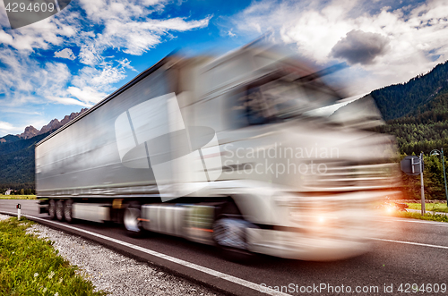 Image of Truck rushes down the highway in the background the Alps. Truck 