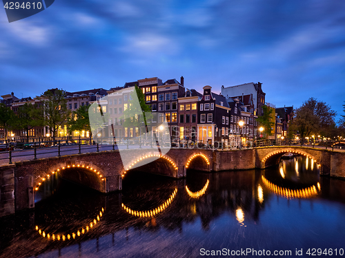 Image of Amterdam canal, bridge and medieval houses in the evening