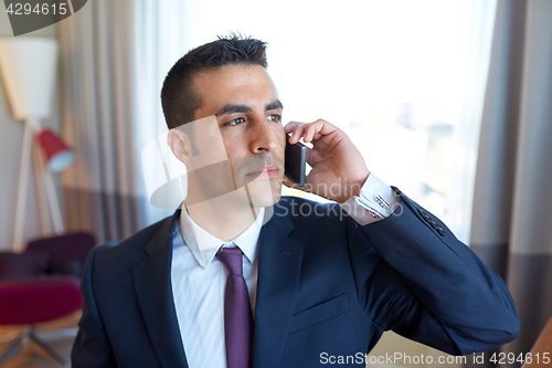 Image of businessman calling on smartphone at hotel room