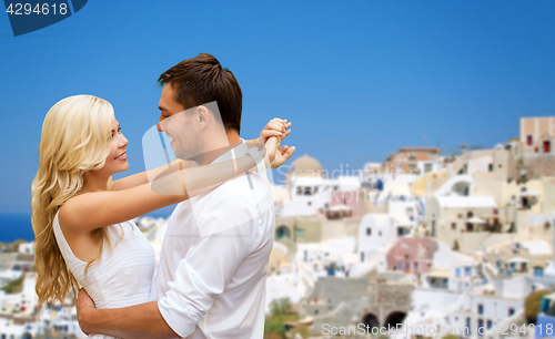 Image of happy couple hugging over santorini island