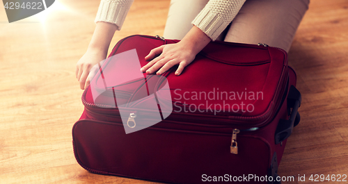 Image of close up of woman packing travel bag for vacation