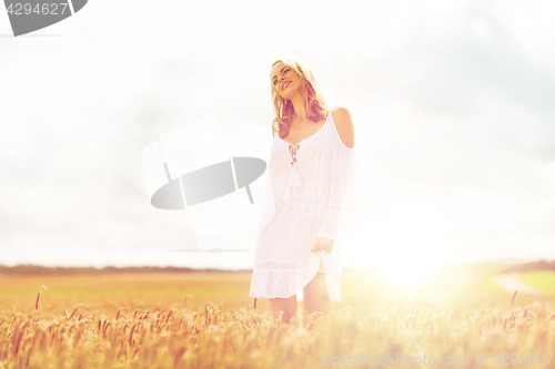Image of smiling young woman in white dress on cereal field
