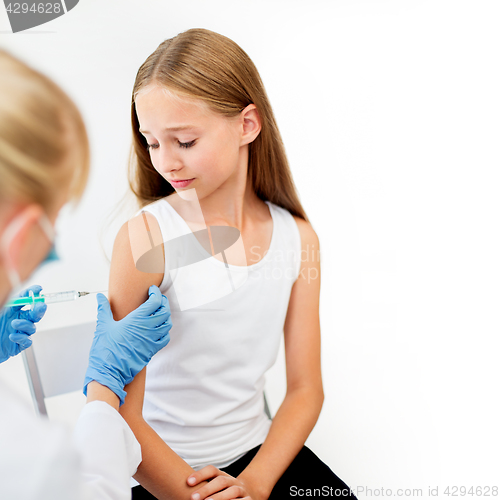 Image of doctor with syringe making injection to girl