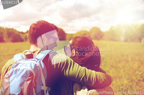 Image of happy couple with backpacks hiking outdoors