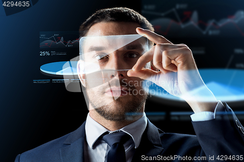 Image of businessman with smartphone and virtual charts