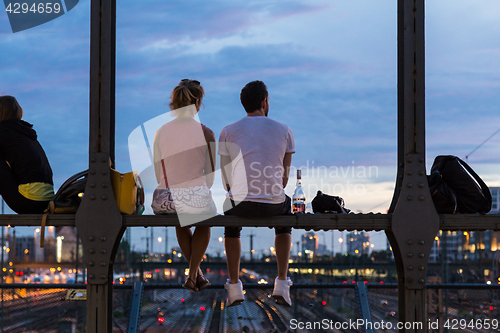 Image of Young couple on romantic date on urban railway bridge, Munich, Germany.