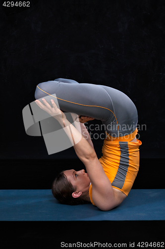 Image of Woman doing Ashtanga Vinyasa Yoga asana Urdhva padmasana