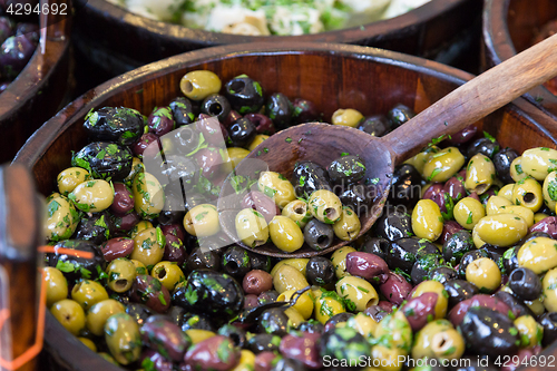 Image of Olives in wooden bowls with serving spoon.