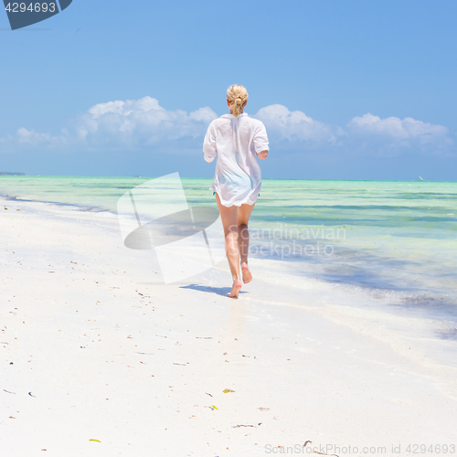 Image of Happy woman having fun, enjoying summer, running joyfully on tropical beach.