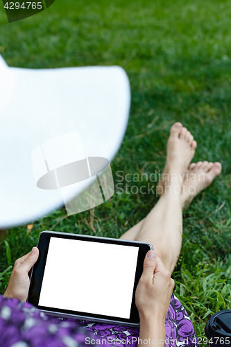 Image of Woman on grass with tablet