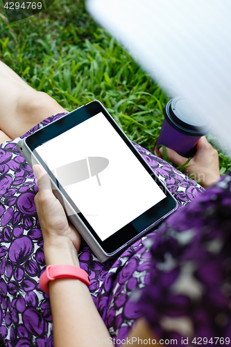 Image of Woman on grass with tablet