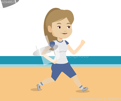 Image of Young sporty woman jogging on the beach.