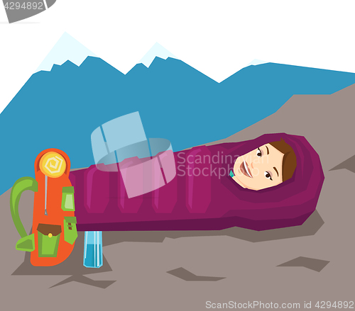 Image of Woman resting in sleeping bag in the mountains.