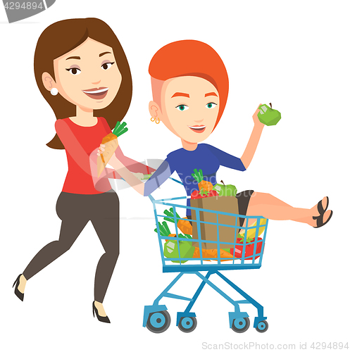 Image of Couple of friends riding by shopping trolley.