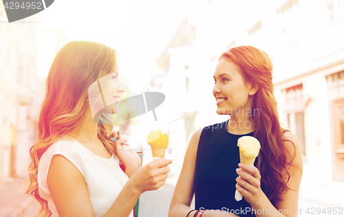 Image of woman with shopping bags and ice cream in city