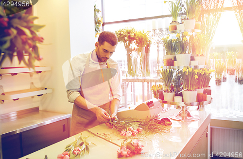 Image of florist man making bunch at flower shop