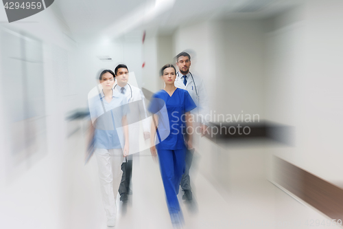 Image of group of medics or doctors walking along hospital