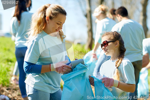 Image of volunteers with garbage bags cleaning park area