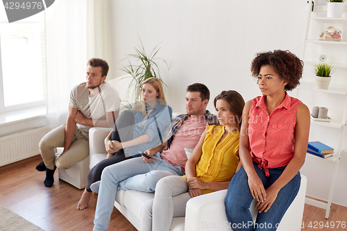 Image of sad friends watching tv at home