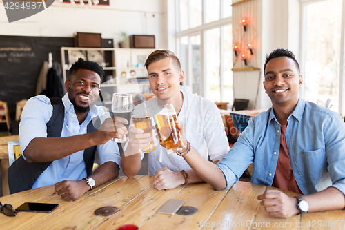 Image of happy male friends drinking beer at bar or pub