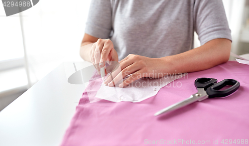 Image of woman with pattern and chalk drawing on fabric