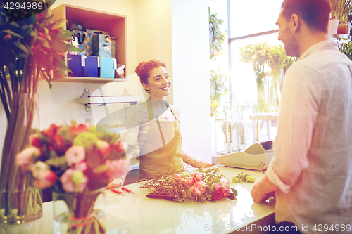 Image of smiling florist woman and man at flower shop