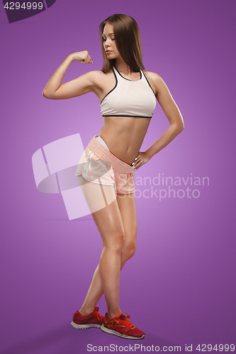 Image of Muscular young woman athlete posing at studio