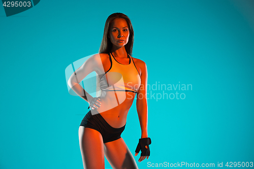 Image of Muscular young woman athlete posing at studio