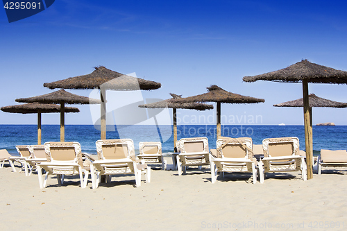 Image of Chairs and umbrellas on a beautiful sandy beach at Ibiza