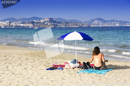 Image of Ibiza sandy beach young girl under a umbrella