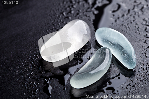 Image of three wet pieces of glass polished by the sea