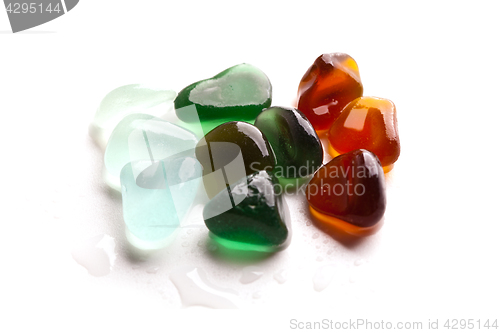 Image of wet pieces of glass polished by the sea isolated on white