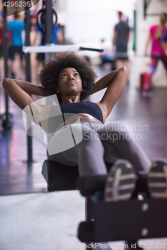 Image of black woman doing sit ups at the gym