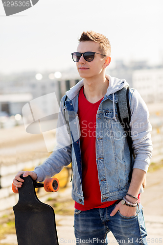 Image of happy young man or teenage boy with longboard