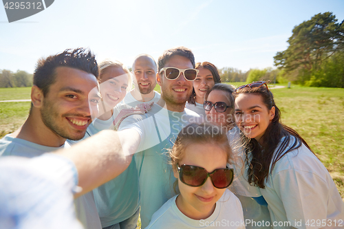 Image of group of volunteers taking selfie by smartphone