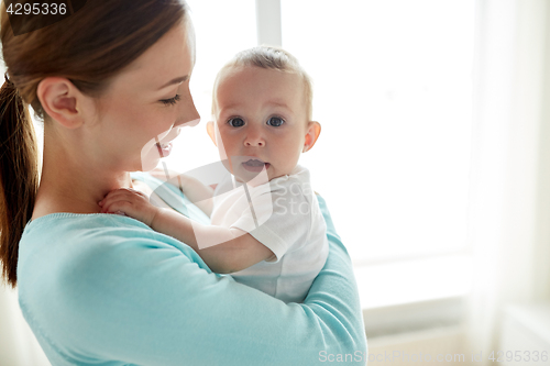 Image of happy young mother with little baby at home