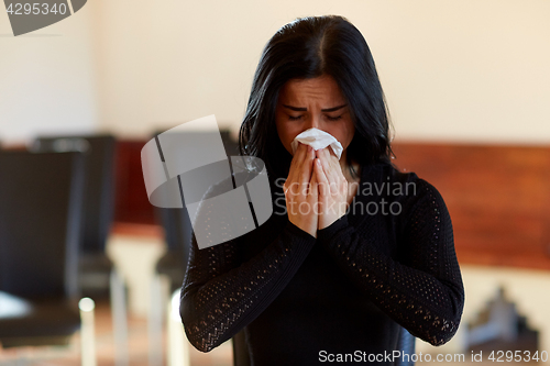 Image of crying woman with wipe at funeral in church