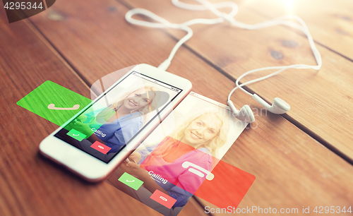 Image of close up of smartphone and earphones on wood