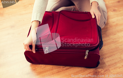 Image of close up of woman packing travel bag for vacation