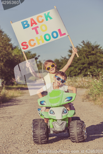 Image of Happy little children playing on road at the day time. They driv