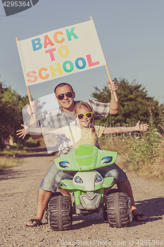 Image of Father and daughter playing on the road at the day time.