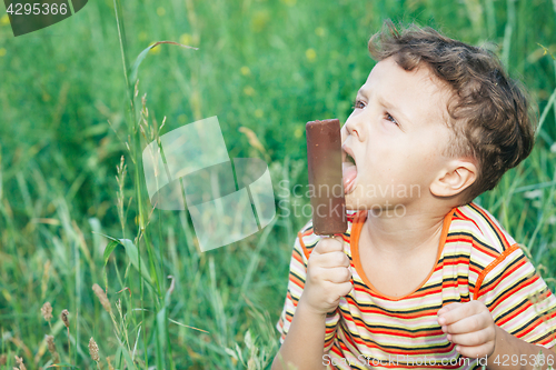 Image of little boy eating ice cream in the park