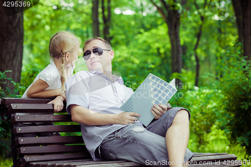 Image of Father and son playing at the park on bench at the day time.