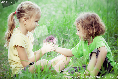 Image of Two happy children  playing near the tree at the day time.