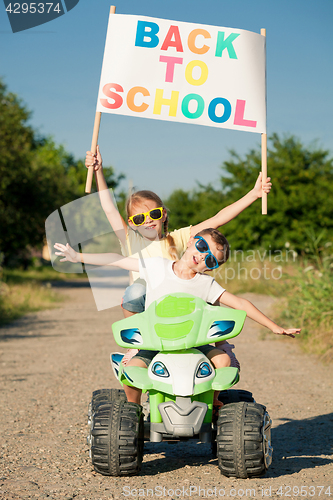 Image of Happy little children playing on road at the day time. They driv