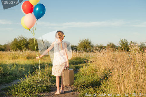 Image of Happy little girl playing on road at the day time.